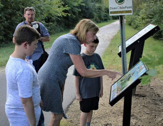 Ohio First Lady Fran DeWine and two young boys read a page from the book "The Hike" by Alison Farrell on the Let's Read 20 Book Walk that is now part of the Marion Tallgrass Trail. DeWine helped to dedicate the book walk during a ceremony held Monday, Sept. 19, 2022, at the trailhead on Holland Road west of Marion.