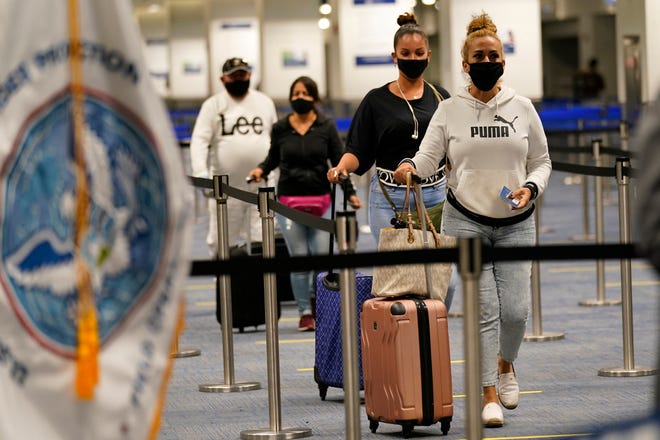 International passengers arrive at Miami International Airport before they are screened by U.S. Customs and Border Protection on Nov. 20, 2020, in Miami.