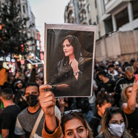 A protester holds a portrait of Mahsa Amini  durin