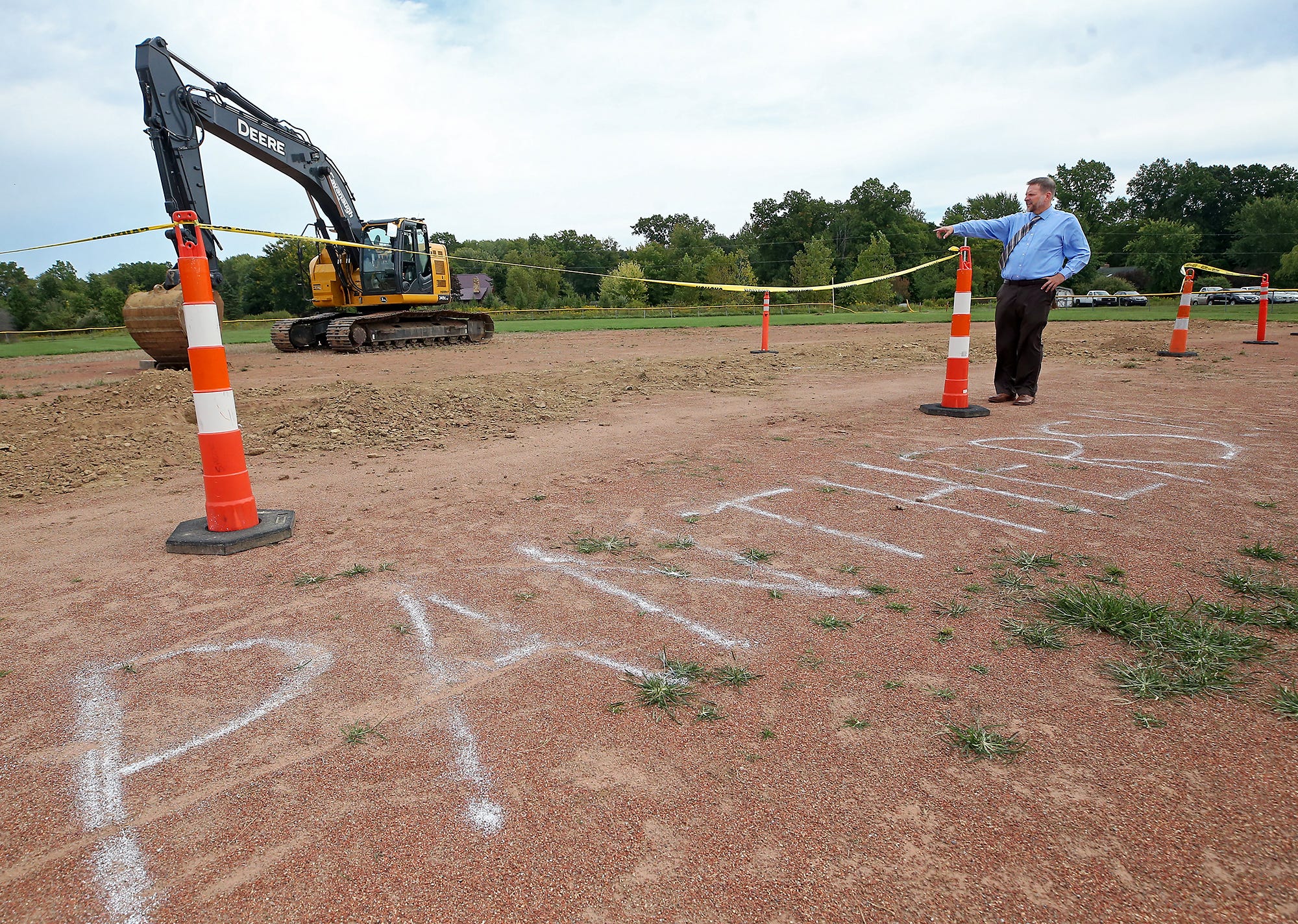 Manchester High School Principal Scott Ross shows the area on what is now the infield of the baseball field that will be the front walkway of the new high school building in New Franklin.