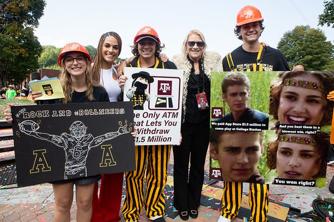 Zackary Car, center, poses with his winning poster during ESPN 'GameDay' festivities on Saturday, Sept. 17, 2022, at Appalachian State University. Others in the photo are, from left to right, poster contest winner and App State junior Annilyn Impara, ESPN College 'GameDay' reporter Jess Sims, Carr, App State Chancellor Sheri Everts and poster contest winner and App State sophomore Ethan Cagle.