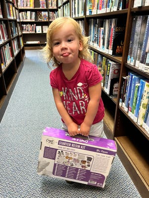 Rylan Aldrich, 2, of Watchung, won SCLSNJ's Summer Reading Challenge Interlox Blocks prize, but preferred carrying the Resin Jewelry Kit that her sister won. Aldrich read 69 total days this summer by listening to stories every day from June 13 to Aug. 20.