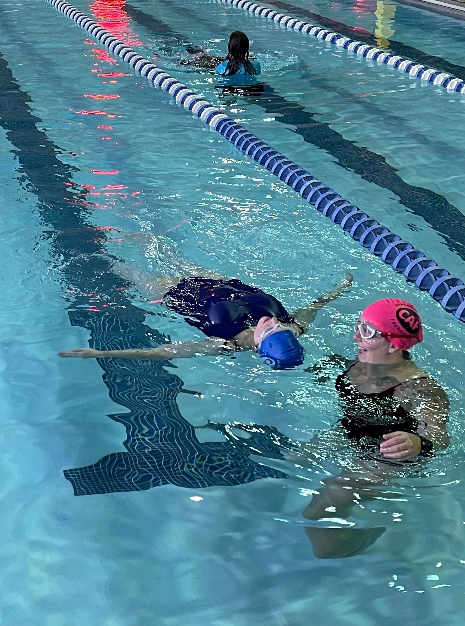 Connie Hanafy of Sewell (right, pink cap) helps Christie Rogero of Voorhees float on her back for the first time "probably ever, even when I had two legs" at a Challenged Athletes Foundation event.