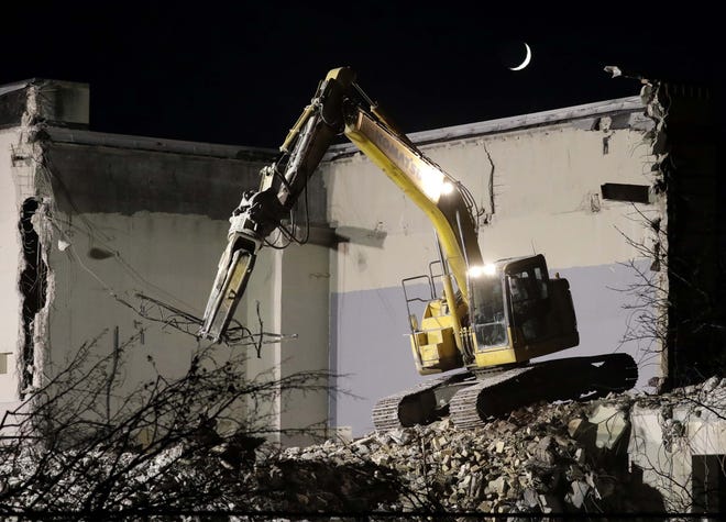 The waxing crescent moon appears above the demolition of the Sheboygan Armory, Tuesday, November 17, 2020, in Sheboygan, Wis.