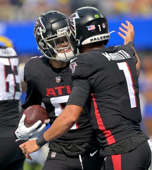 Falcons wide receiver Drake London is congratulated by quarterback Marcus Mariota after the Moorpark High graduate caught his first NFL touchdown pass against the Rams at SoFi Stadium on Sunday.