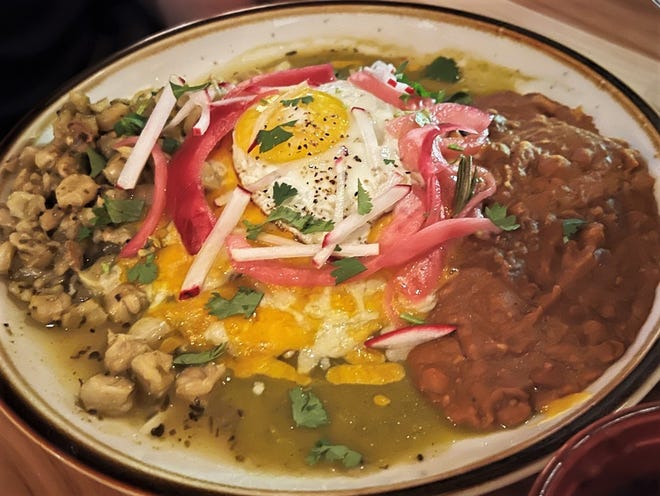 Enchiladas de chile verde apiladas cubiertas con un huevo frito de El Coyote Bar and Cantina, que abre el viernes en el vecindario Britton de la ciudad de Oklahoma.