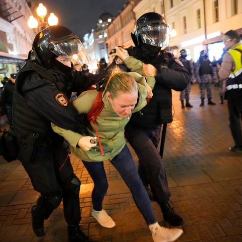 Riot police detain a demonstrator during a protest