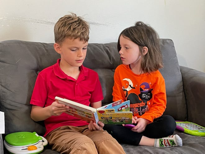 Jensen Dison, 6, and Grayson Dison, 4, read a book together. Jensen is a first grader at North Linden Elementary School in Columbus City Schools, which received a one-star rating for early literacy on the latest state report cards.