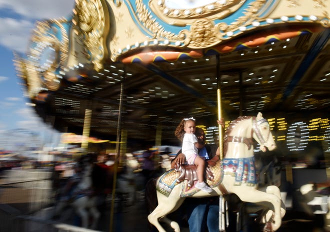 Three year old Bella Luna Quintero rides the South Plains Fairgrounds carousel on day one of the South Plains Fair, Thursday September 22, 2022.