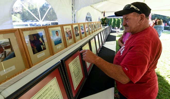 Sep 23, 2022; Brookwood, AL, USA; Kenny Nichols looks at photographs of the miners who were killed as coal miners and family members mark the 21st Anniversary of the mine explosion at the Jim Walter Resources Mine No. 5 in Brookwood that claimed 13 lives on Sept. 23, 2001. Nichols was part of the mine rescue team working the explosion.
