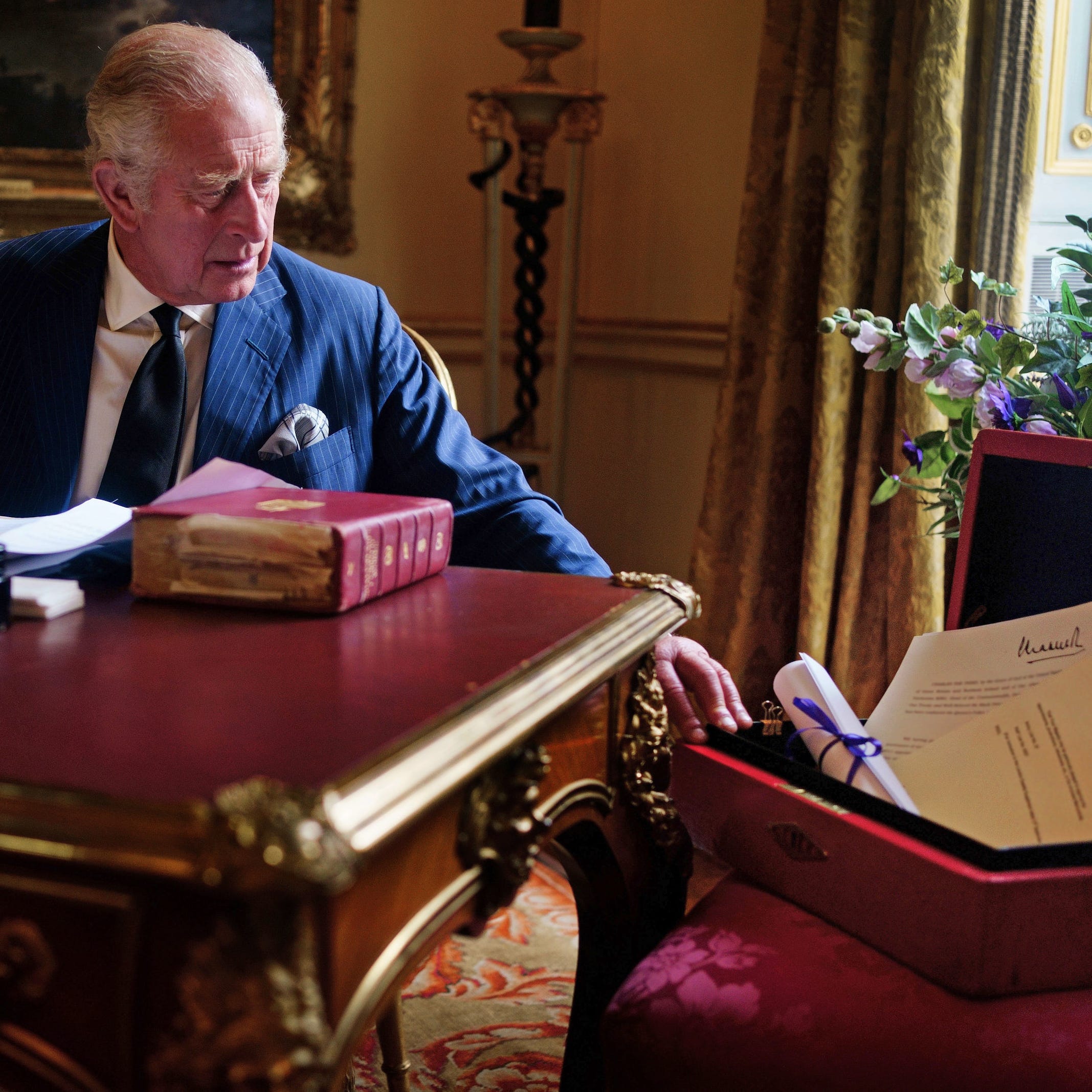 King Charles III carries out official government duties from his red box in the Eighteenth Century Room at Buckingham Palace, in a picture released by the palace on Sept. 23, 2022.