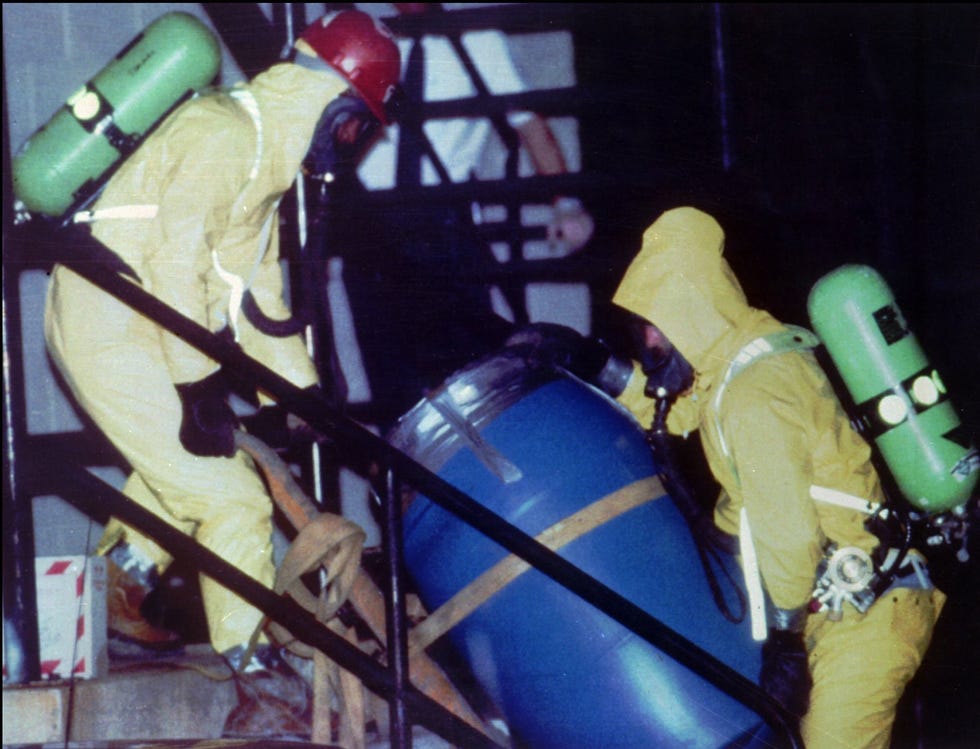 Two men wearing protective clothing, remove a barrel from a Milwaukee apartment on July 23, 1991, where serial murderer Jeffrey Dahmer lived.