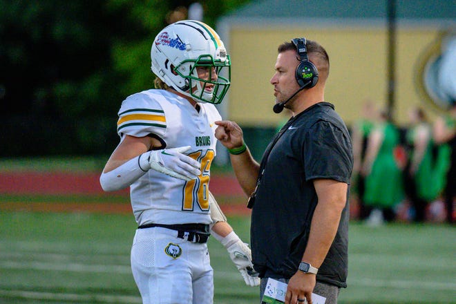 Rock Bridge head coach Matt Perkins works out a play with Jack Bower (16) during a game against Jefferson City earlier this season.