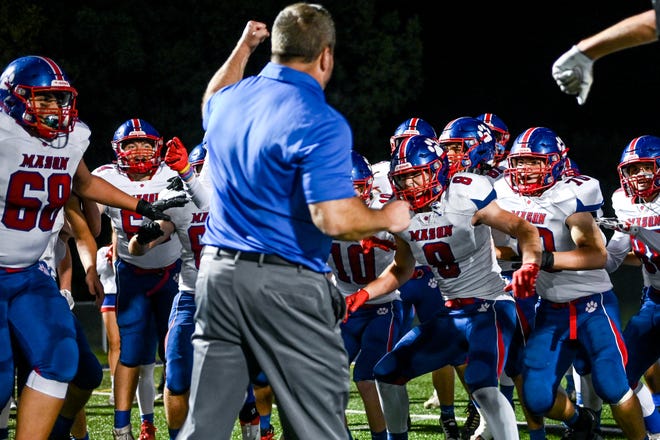 Mason celebrates with head coach Gary Houghton after beating Haslett on Friday, Sept. 23, 2022, at Haslett High School.