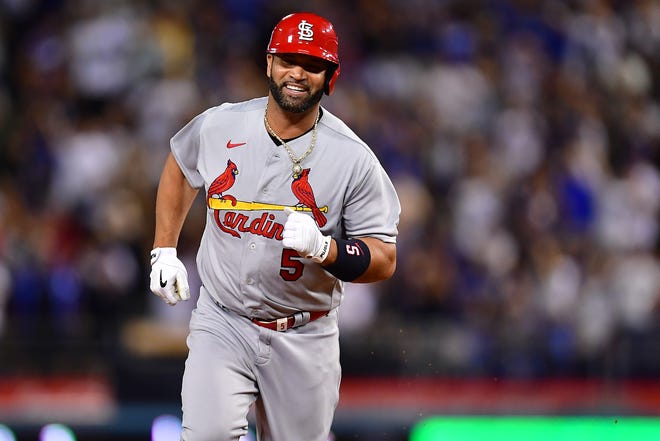 Albert Pujols smiles as he rounds the bases after hitting his 700th home run.