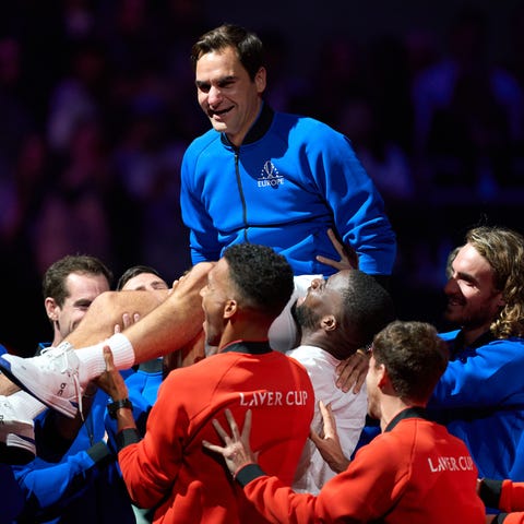 Roger Federer is hoisted by fellow tennis players 
