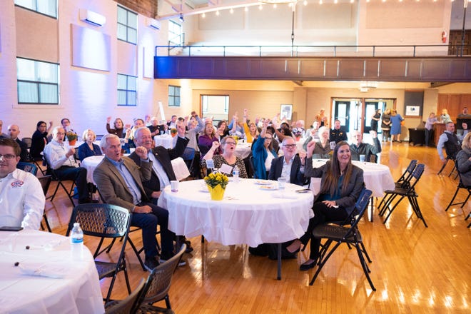 Attendees at the Lenawee Community Foundation's annual meeting Thursday, Sept. 22, 2022, at the Adrian Armory Events Center raise buckeye nuts and call out "Oh, yay!" in recognition of late philanthropist Frank Dick, a big fan of the Ohio State Buckeyes who died Sept. 5.