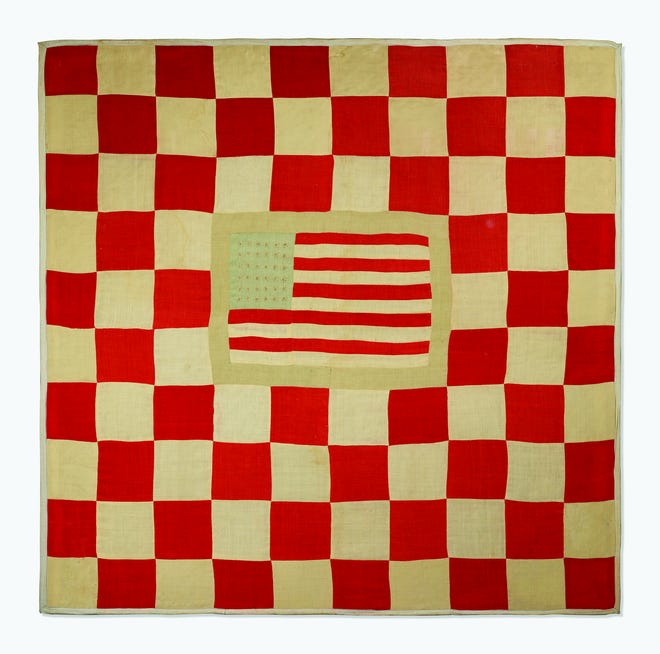 This quilt features an American flag with 36 stars, indicating that it was made about 1865. Most antique quilts are harder to date.