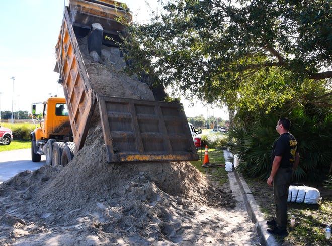 Sand was unloaded from a dump truck at Mitchell Ellington Park on north Merritt Island on Monday morning. Residents of Brevard County received up to 10 free sandbags per vehicle.