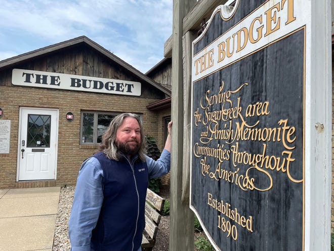 Milo Miller, publisher of The Budget newspaper, stands in front of its Sugarcreek, Ohio office location. The paper serves Anabaptist people across the country.