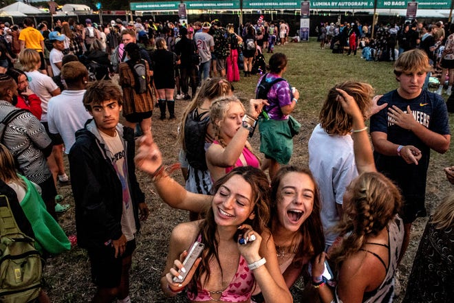 The lucky attendees form a line to re-enter the 2022 Firefly Music Festival in Dover on Sunday, September 26, 2022. The threat of extreme weather has forced a temporary evacuation of all attendees from the venue.