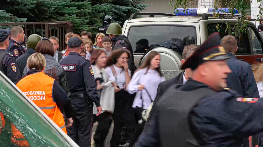 In this image taken from video, school children run from the scene of a shooting at school No. 88 in Izhevsk, Russia, Monday, Sept. 26, 2022. Authorities say a gunman has killed 15 people and wounded 24 others in the school in central Russia. According to officials, 11 children were among those killed in the Monday morning shooting. 