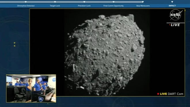 这张来自美国宇航局周一直播的屏幕截图显示了双小行星重定向测试（DART）之前的 Demorphos，该测试对小行星产生了影响，正如马里兰州劳雷尔 DART 总部的美国宇航局团队（左下）所看到的那样。