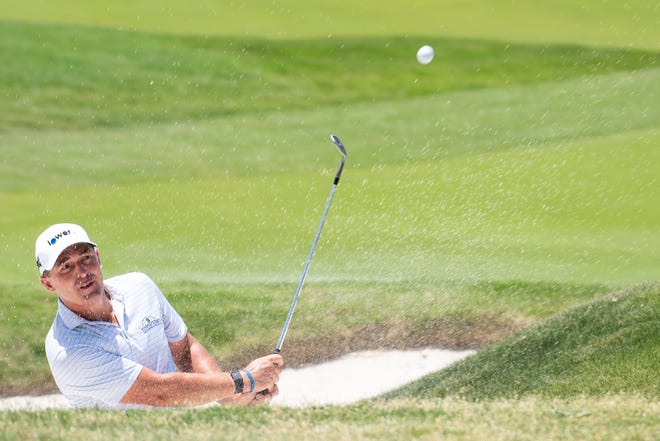 Justin Lower hits a ball out of a bunker on the sixth hole during the third round of the AT&T Byron Nelson golf tournament in McKinney, Texas, May 14, 2022.