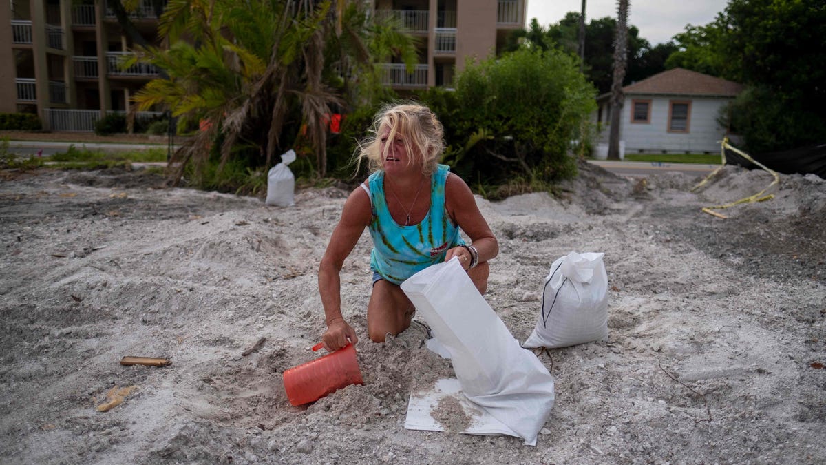 Barbara Schueler fills sandbags in a vacant lot in preparation for Hurricane Ian in St. Pete Beach, Florida on September 26, 2022.