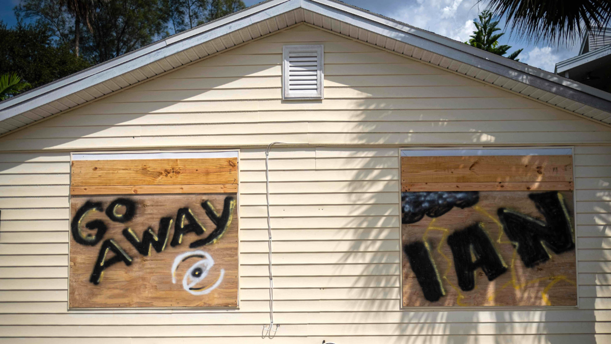 A boarded-up house with "Go Away Ian" painted on the boarded-up windows, is seen ahead of the arrival of Hurricane Ian in Indian Shores, 25 miles West of Tampa, Florida on September 26, 2022.