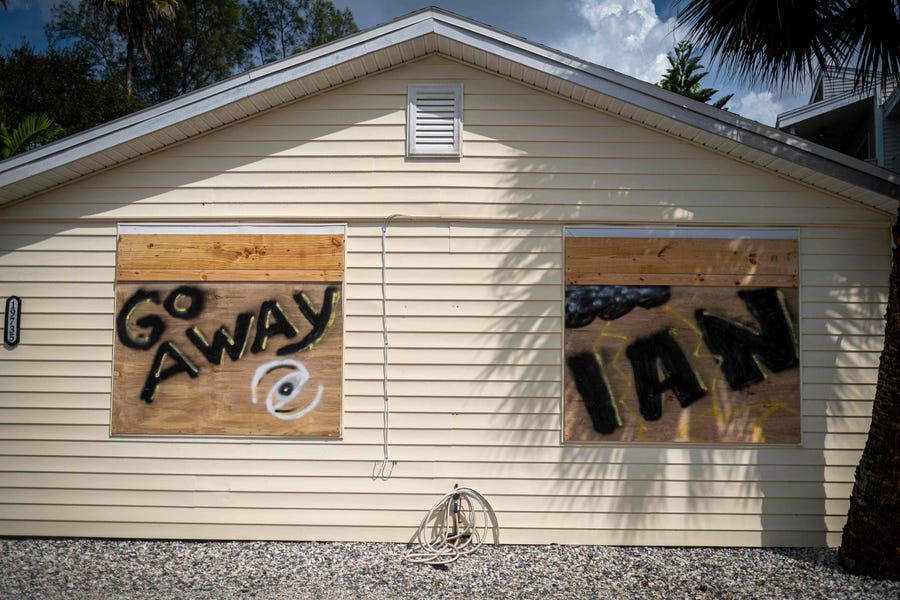 A boarded up house with "Go Away Ian" painted on the boarded up windows, is seen ahead of the arrival of Hurricane Ian in Indian Shores, 25 miles West of Tampa, Florida on September 26, 2022.