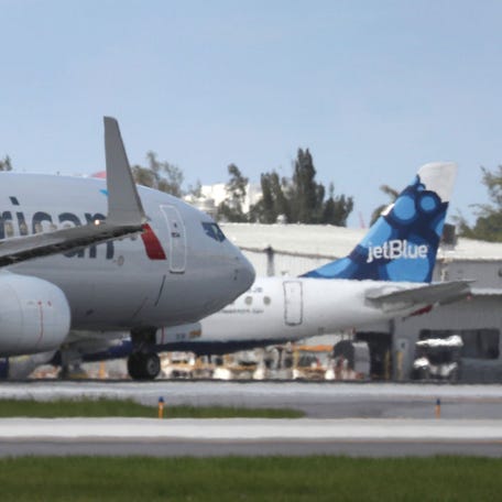 An American Airlines plane takes off near a parked JetBlue plane at the Fort Lauderdale-Hollywood International Airport on July 16, 2020.