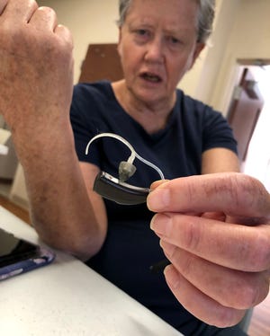 Barbara Ward, 69, offers a closer look at one of her hearing aids after a support group meeting hosted by the Hearing Loss Association of Delaware, on Sept. 8, 2022, in Newark Senior Center.