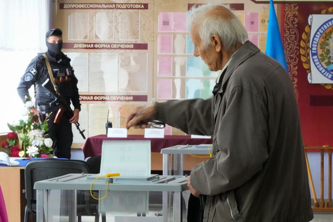 A man casts his ballot during a referendum in Luhansk, Luhansk People's Republic controlled by Russia-backed separatists, eastern Ukraine, Tuesday, Sept. 27, 2022.