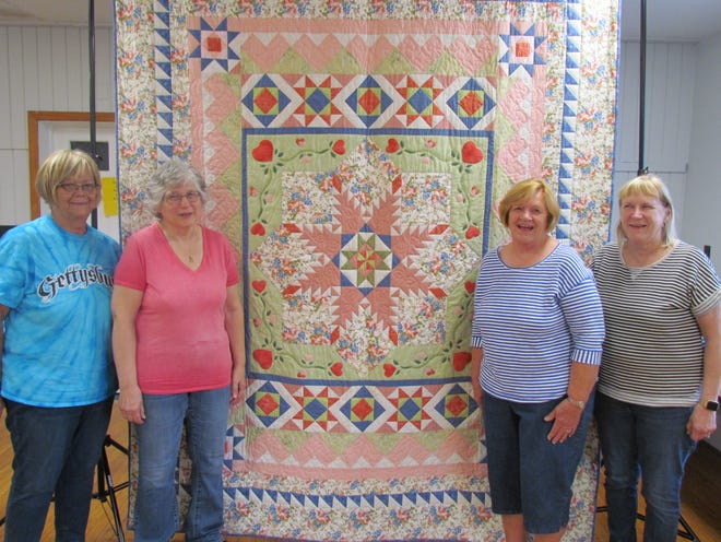The Pleasant Mount Quilters Guild will auction off this queen sized, hand-stitched "Feather Star Medallion" quilt at the 8th Harvest Quilt Show, coming up on October 8. From left: Sue Keyes, President, Lorraine Fenstermahcer, Quilt Show Committee Co-chair, Mary Ann Harkenreader, Vice President, and Linda Williams, Quilt Show Committee Co-chair.