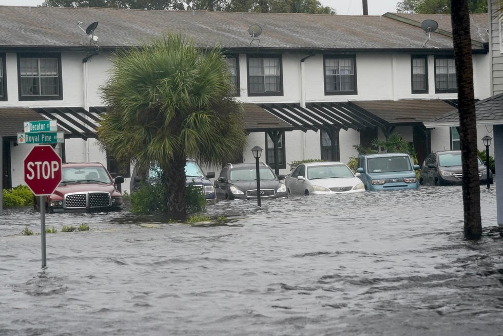 Los vehículos se encuentran en las aguas de la inundación el 29 de septiembre fuera de Palm Isle Apartments en Orlando después del huracán Ian.