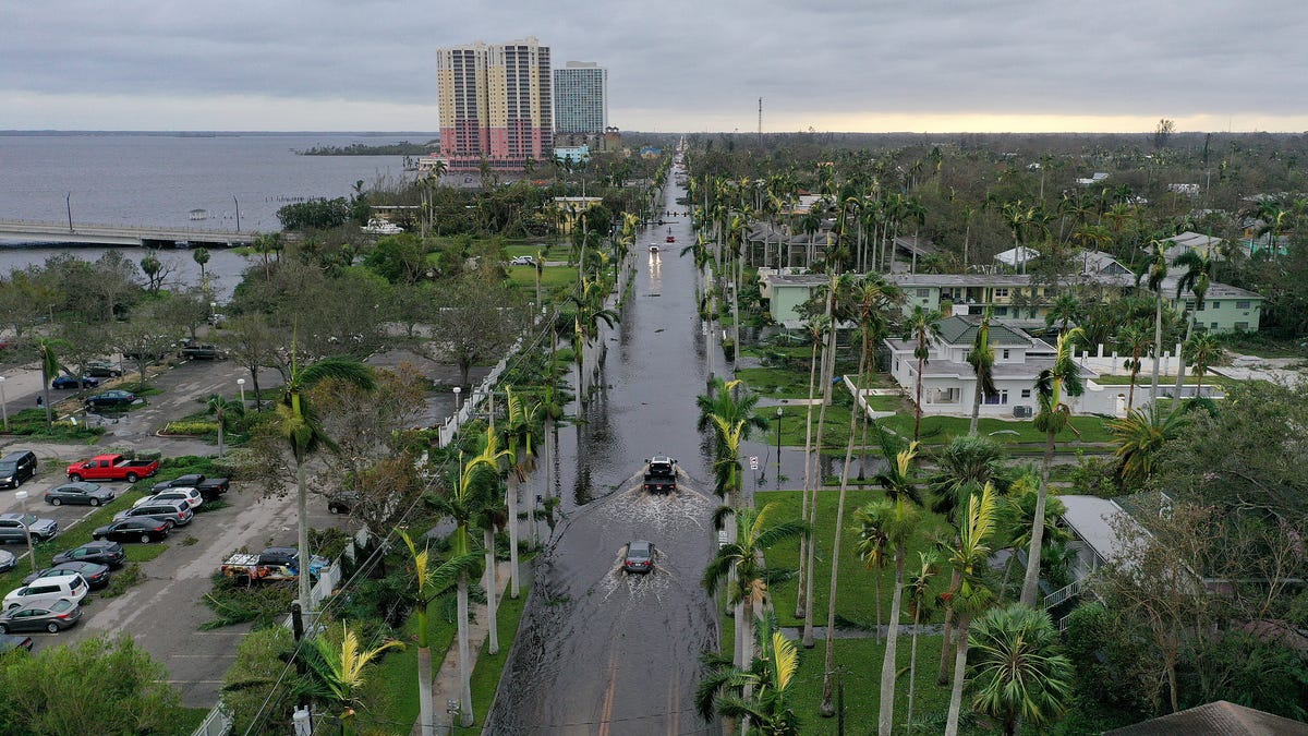 In this aerial view, vehicles make their way through a flooded area after Hurricane Ian passed through the area on Sept. 29, 2022 in Fort Myers, Fla. The hurricane brought high winds, storm surge and rain to the area causing severe damage.