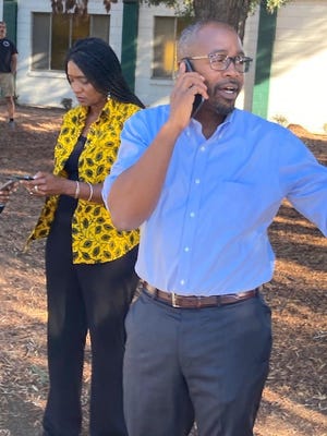 Oakland City Council members Treva Reid, left, and Loren Taylor, right, gather outside the family reunification center after a shooting at a nearby school left six people injured.