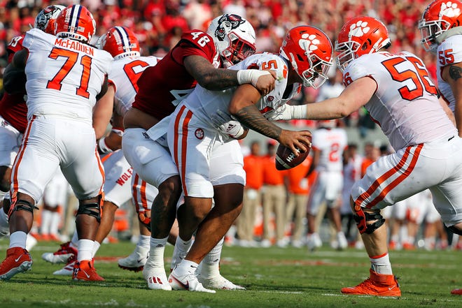 North Carolina State's Cory Durden (48) grabs a hold of Clemson's DJ Uiagalelei (5) for a sack during the first half of their 2021 game in Raleigh, NC, Saturday, Sept.  25, 2021.