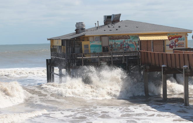 Waves crash against the posts of the Sunglow Pier and Crabby Joe's Deck & Grill restaurant in Daytona Beach Shores in the wake of Tropcal Storm Ian. A portion of the iconic privately owned pier was sheared off during Ian's assault on Volusia County. Its owners are working toward repairing and reopening the restaurant and the pier.