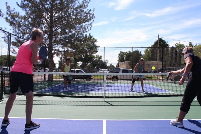 Shauna Peters (right) returns a serve to Carol Nance (back left) and Kathy Neve (back right) during a pickleball drill at the Mineral Palace Park pickleball courts on Sept. 29, 2022.