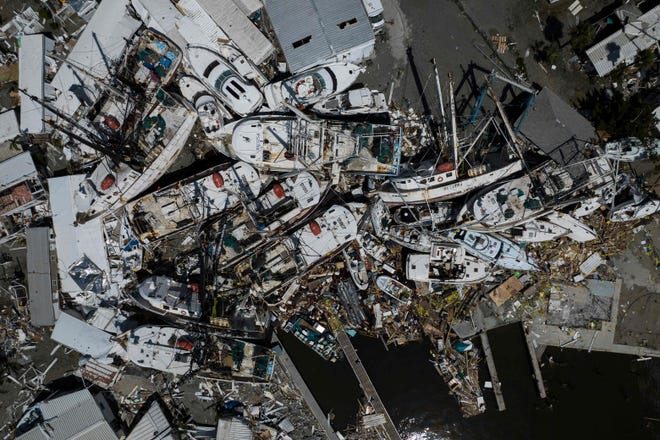 An aerial picture taken on September 29, 2022 shows piled up boats in the aftermath of Hurricane Ian in Fort Myers, Florida.