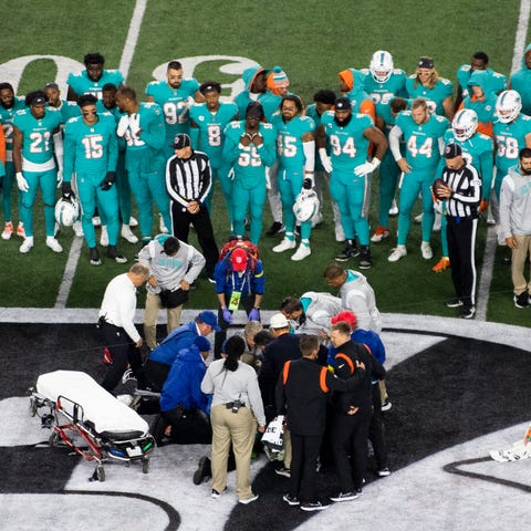 Teammates gather around Miami Dolphins quarterback