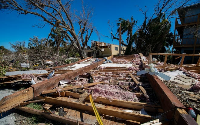 A torn roof sits in front of his home as hurricane winds blew through the Pine Island structure.  Major signs of damage were present in parts of the island as high winds and flood waters from Hurricane Ian impacted the area.  This image was taken on Friday, September 30, 2022.
