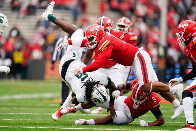 Michigan State tight end Maliq Carr, left, is upended by Maryland defensive lineman Mosiah Nasili-Kite, top, and linebacker Fa'Najae Gotay (9) while running with the ball during the first half of an NCAA college football game, Saturday, Oct. 1, 2022, in College Park, Md. (AP Photo/Julio Cortez)