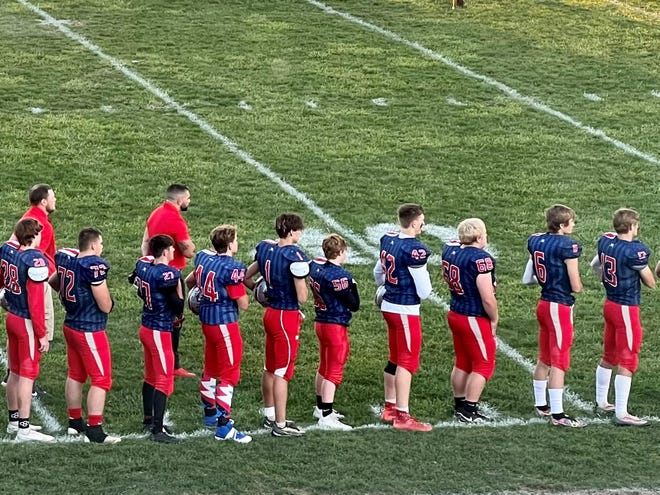 Elgin's football team, wearing it's patriotic jerseys, stand at attention during the national anthem before Friday's home game with Ridgedale.