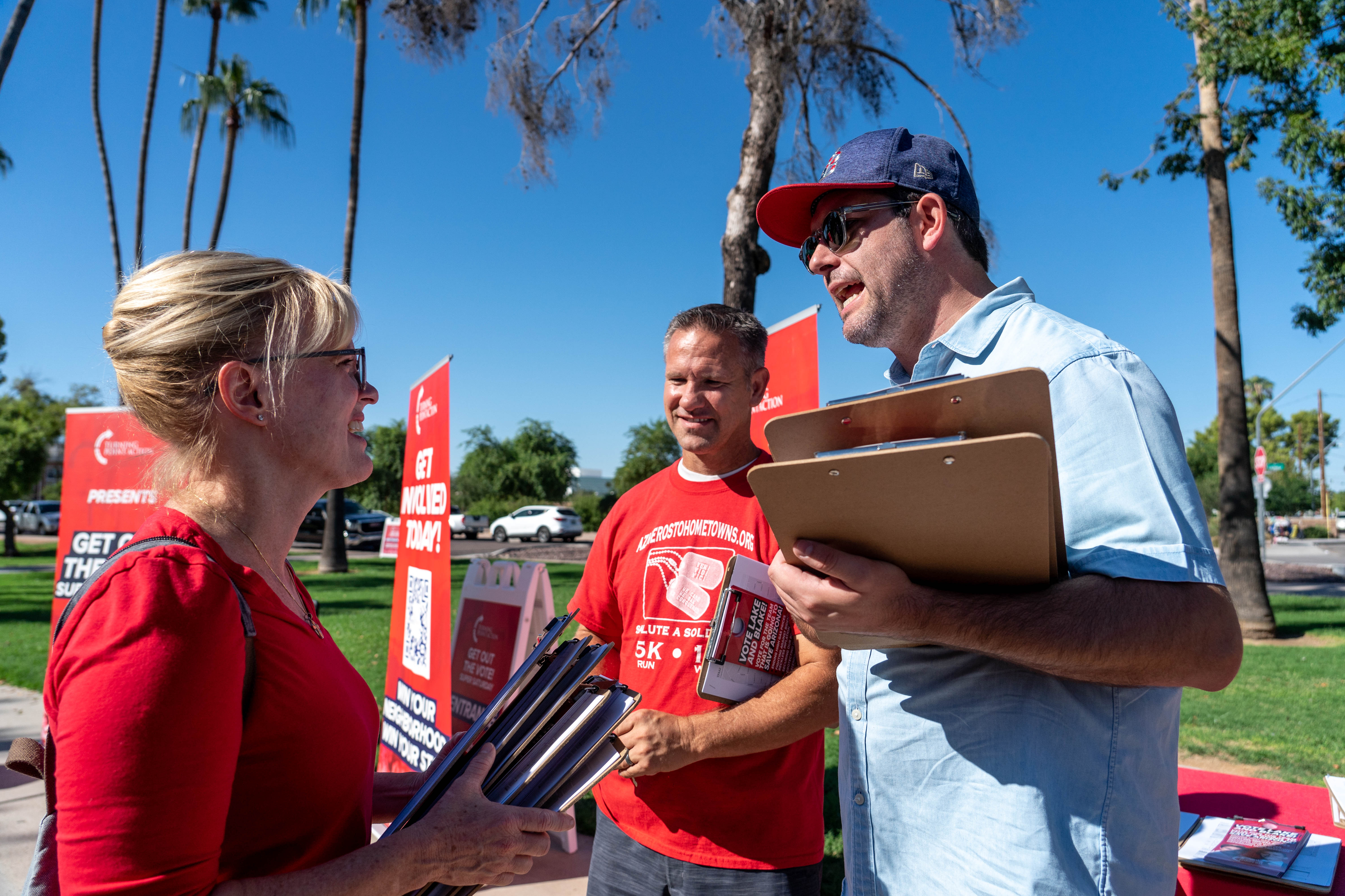 Tyler Bowyer, chief operating officer of Turning Point USA, (right) speaks with attendees after a Turning Point USA rally in Mesa on Oct. 1, 2022.