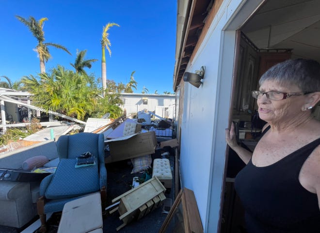Fort Myers resident Sharon Popham assesses the damage caused by Hurricane Ian to her mobile home Friday morning.