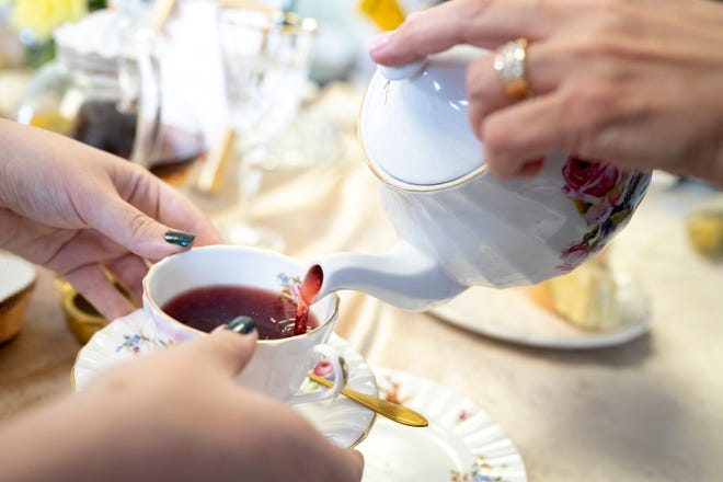 2 ottobre 2022; Columbus, Ohio, Stati Uniti; Oksana Williams versa la tisana fresca del mercato contadino per Amanda Schlain durante un tea party pomeridiano al Flourish Studio. Credito obbligatorio: Joseph Schiller - Columbus Dispatch