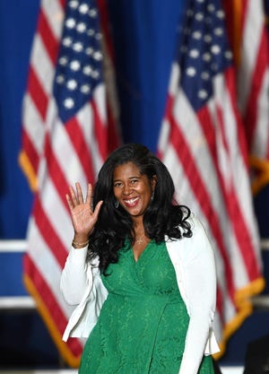 Kristina Karamo, the Republican candidate for secretary of state, waves to the crowd on her way to the podium Saturday night at former president Donald Trump's campaign rally for Michigan Republicans at the Macomb Community College Sports & Expo Center in Warren.